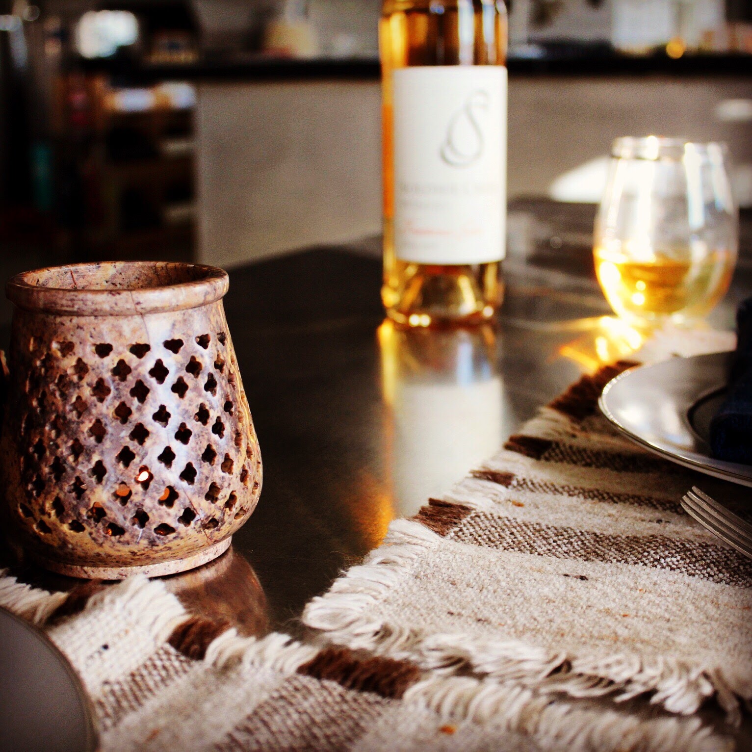 Elegant table setting with a glass of white wine and a decorative lantern at Soldier Creek Winery