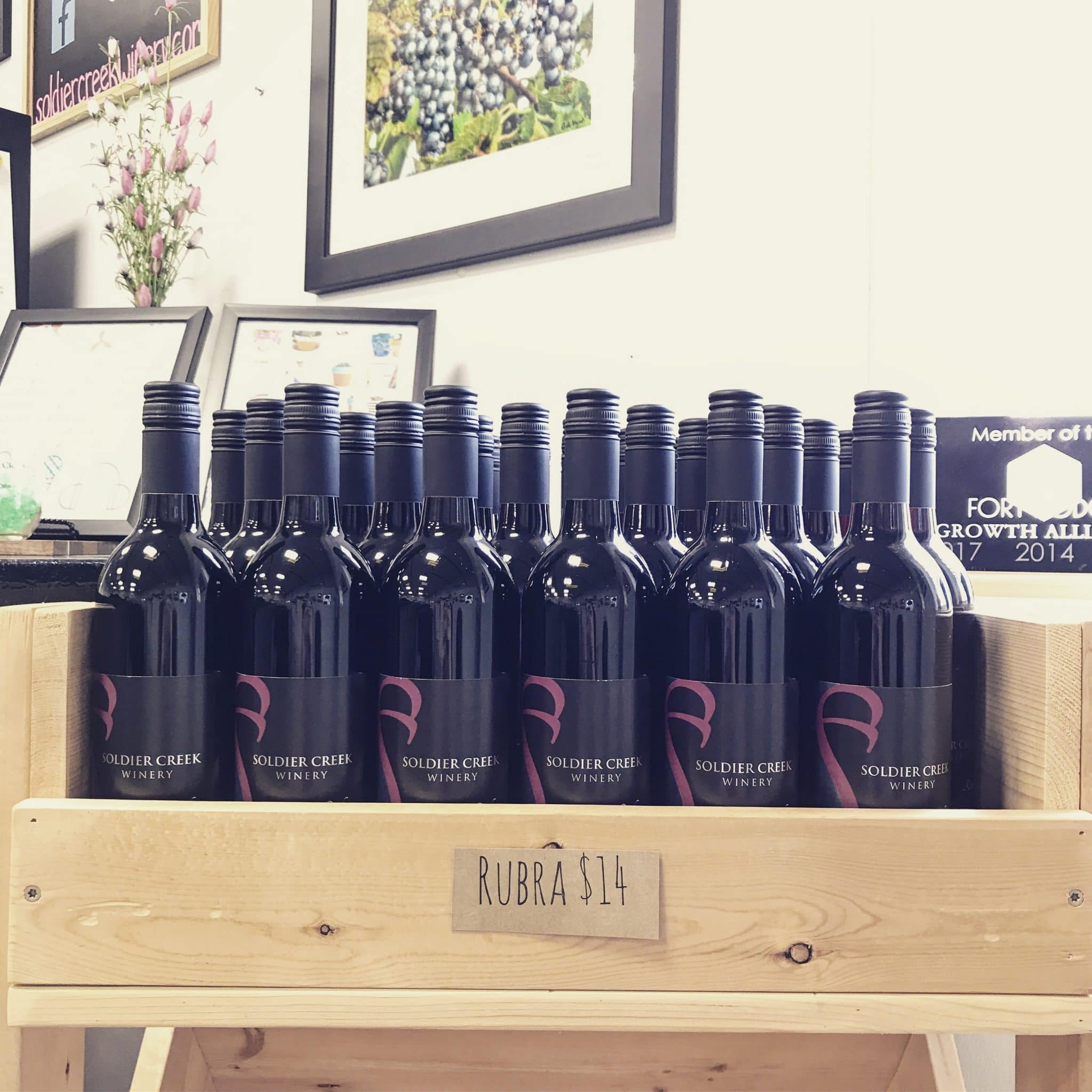 Soldier Creek Winery wine bottles displayed in a wooden rack