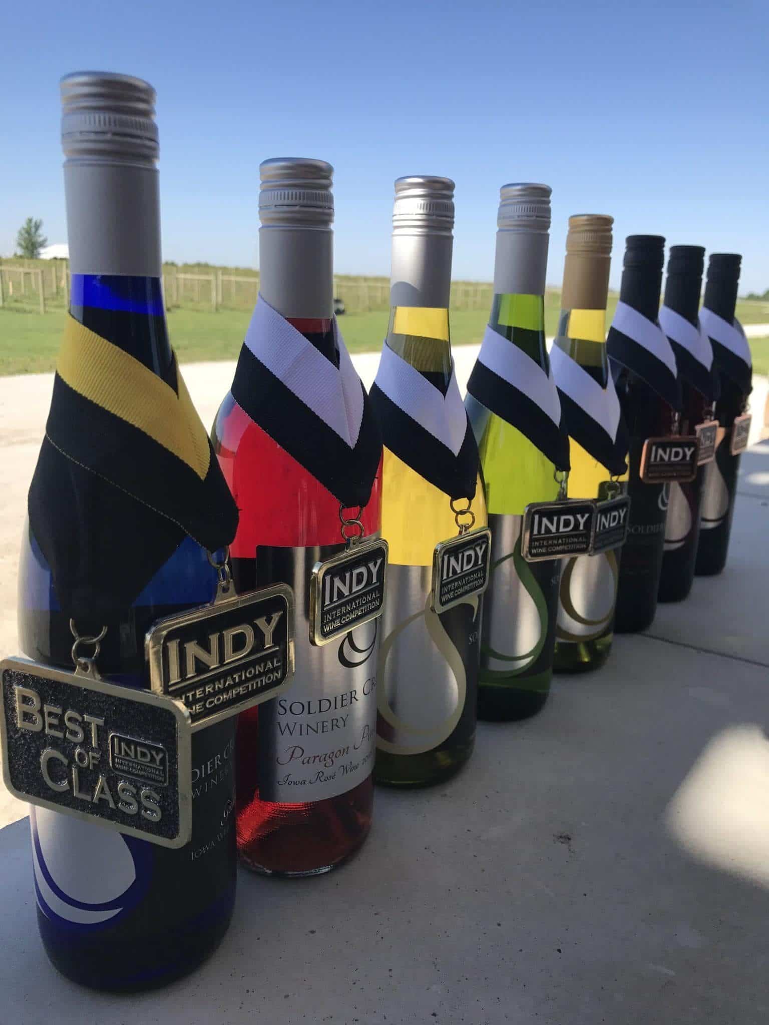 Row of Soldier Creek Winery wine bottles with INDY Best of Class award tags