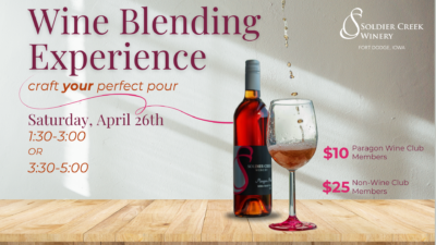 A promotional digital flyer for Soldier Creek Winery’s Wine Blending Experience event. The background features a sunlit wooden table with a bottle of Paragon Pink wine and a glass with wine being poured into it. The text invites attendees to "craft your perfect pour" on Saturday, April 26, with two session options: 1:30-3:00 PM or 3:30-5:00 PM. Ticket prices are $10 for Paragon Wine Club Members and $25 for non-members.