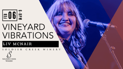 Promotional image for Vineyard Vibrations at Soldier Creek Winery. Features smiling vocalist Liv McNair under blue stage lighting with a microphone. Text reads: “Feb 6 | 6–8 PM,” “Vineyard Vibrations,” and “Liv McNair.”